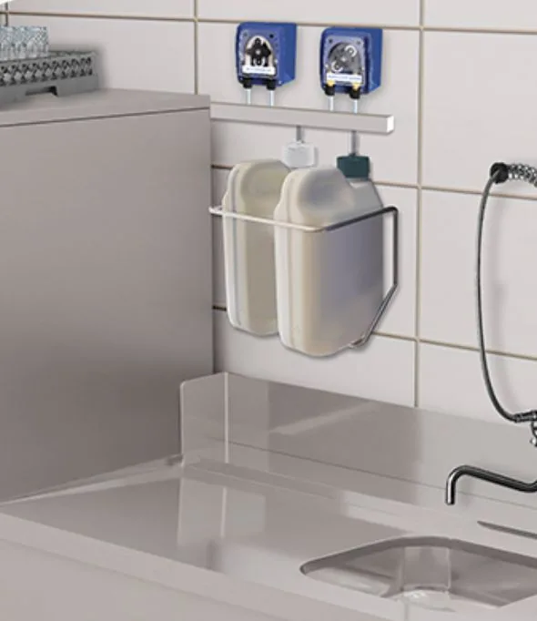 Pompes doseuses au dessus d'une plonge en inox